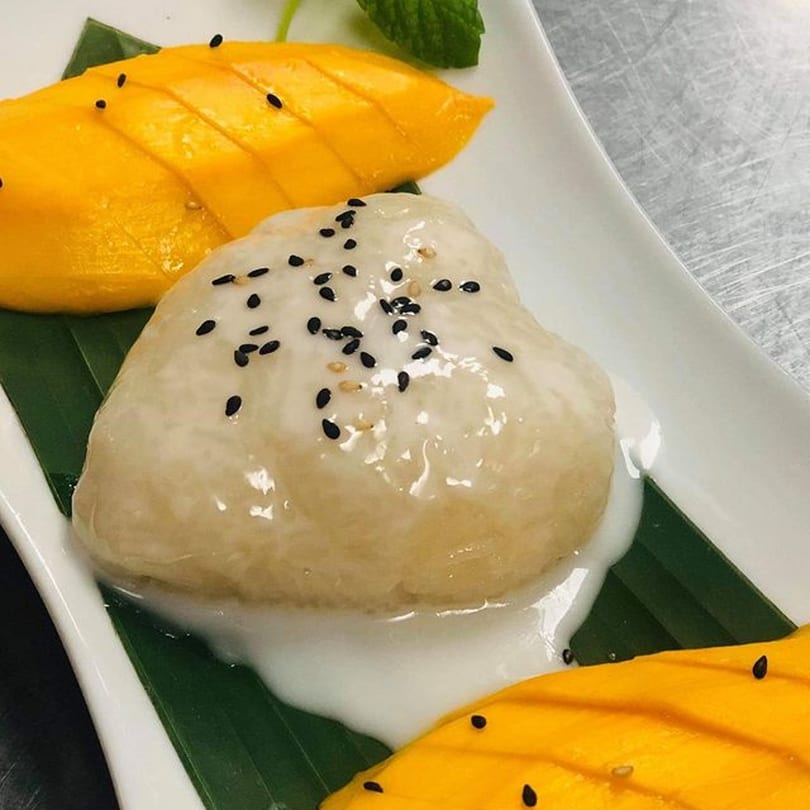 Tamarind Thai Cuisine's mango sticky rice dessert, garnished with black sesame seeds and mint.